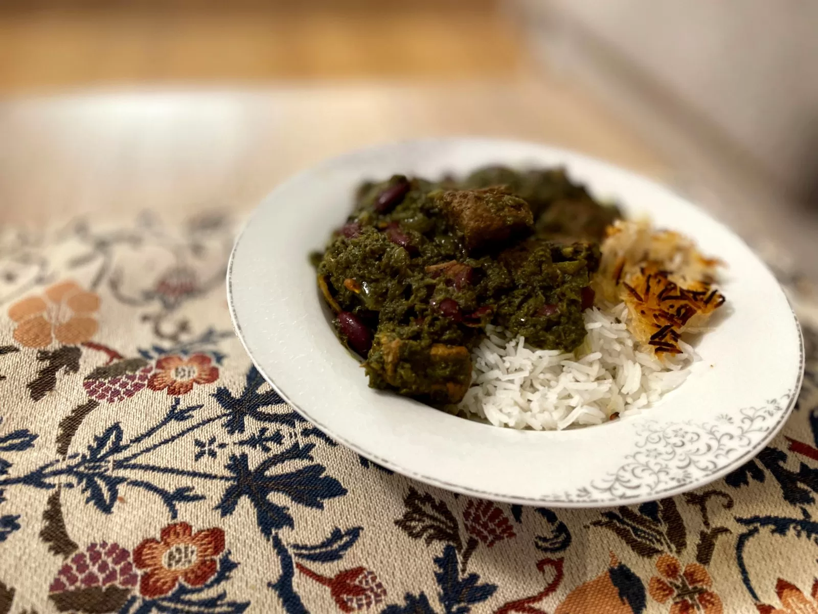 Persian Ghormeh Sabzi with tender pieces of beef, kidney beans and dark fried herbs in a thick green herb sauce, served with basmati rice.